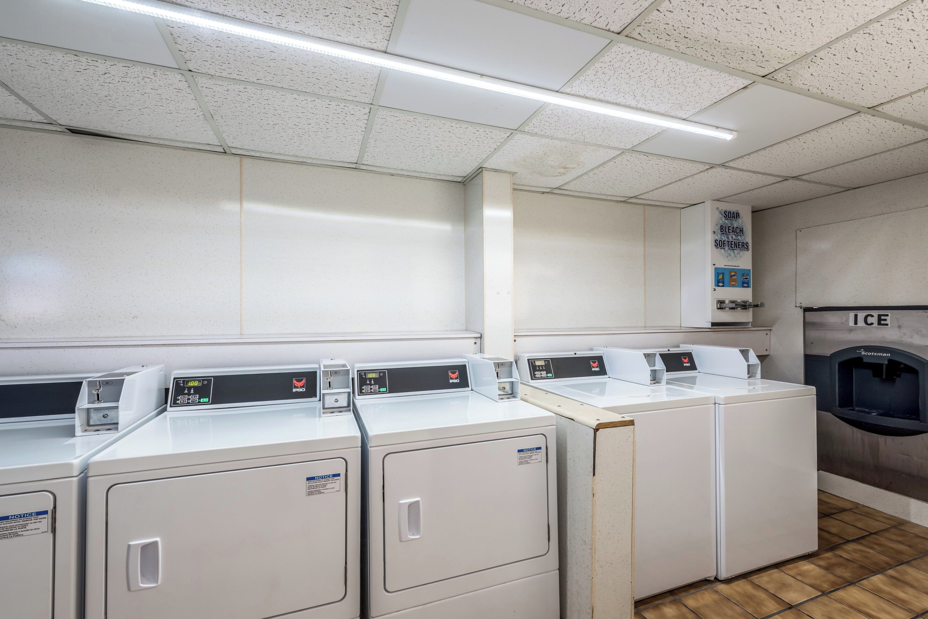 A laundry facility with multiple washing machines, a water softener dispenser, and an ice dispenser.