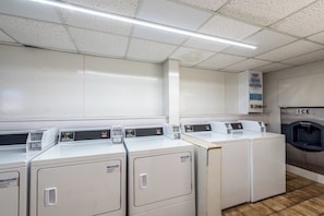 A laundry facility with multiple washing machines, a water softener dispenser, and an ice dispenser. - Red Roof Inn & Suites Pigeon Forge - Parkway (Pigeon Forge)