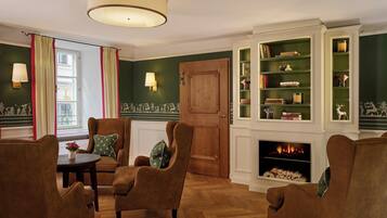 Ein gemütliches Wohnzimmer mit Kamin, bequemen Sitzmöglichkeiten und einer Bücherregal.