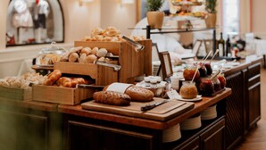 A buffet with various baked goods, including croissants and pastries, and condiments.