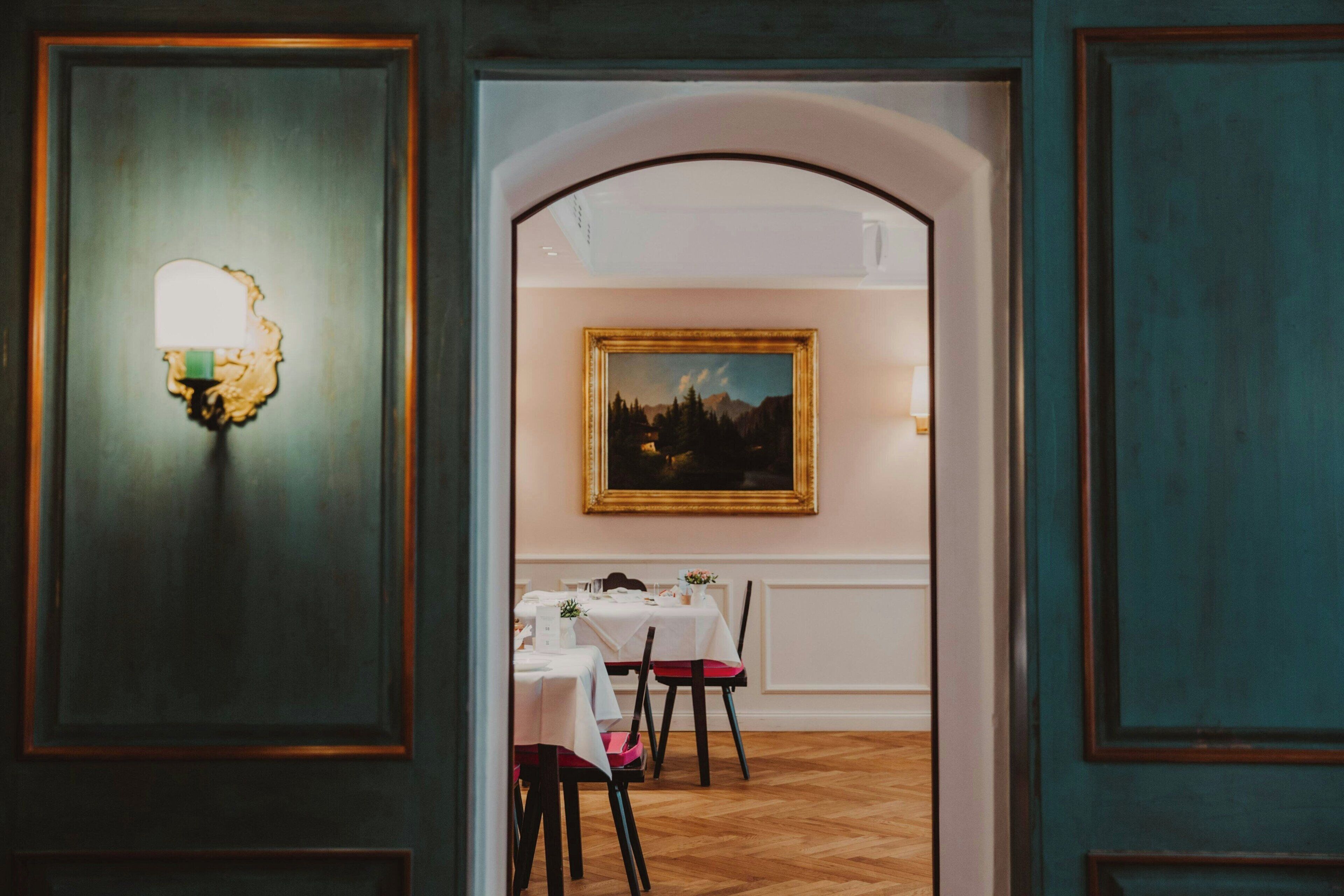 An interior with a dining area, a painting on the wall, and a light fixture.