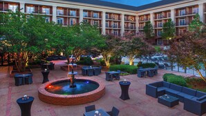 A courtyard with outdoor seating, a fountain, and a building with multiple balconies. - Sheraton Music City Nashville Airport (Nashville)