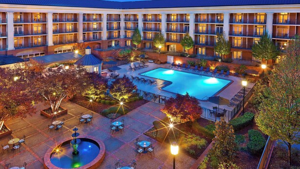 A hotel with a swimming pool, outdoor seating, and a courtyard. - Sheraton Music City Nashville Airport (Nashville)