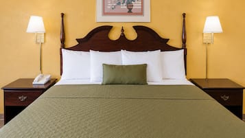 Habitación de hotel con una cama grande, dos mesitas de noche, un teléfono y dos lámparas de pared.