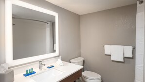A modern bathroom with a large mirror, white sink, and toilet. - Holiday Inn Express Boca Raton-West by IHG (Boca Raton)