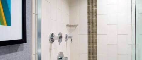 A modern bathroom with a glass shower enclosure, a towel rack, and a toilet.