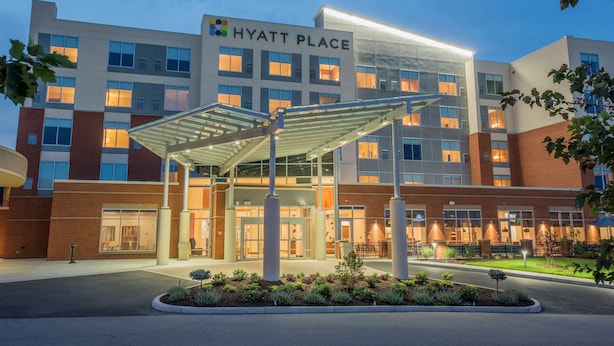 Un hotel Hyatt Place con entrada cubierta, varios pisos y fachada bien iluminada.
