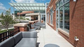 Un patio al aire libre con mobiliario y un paseo cubierto.
