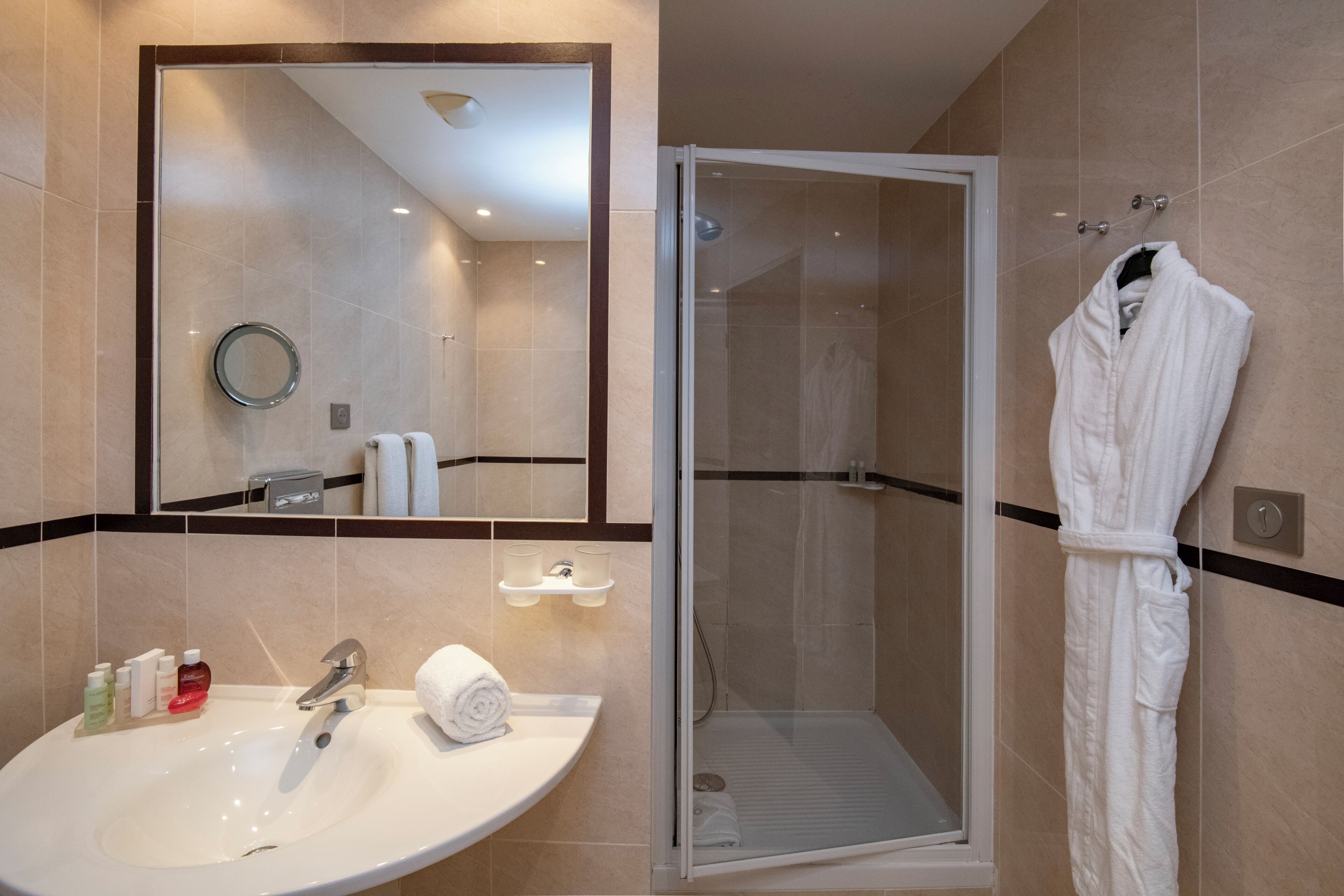 Ein Badezimmer mit Waschbecken, Spiegel und barrierefreier Dusche.