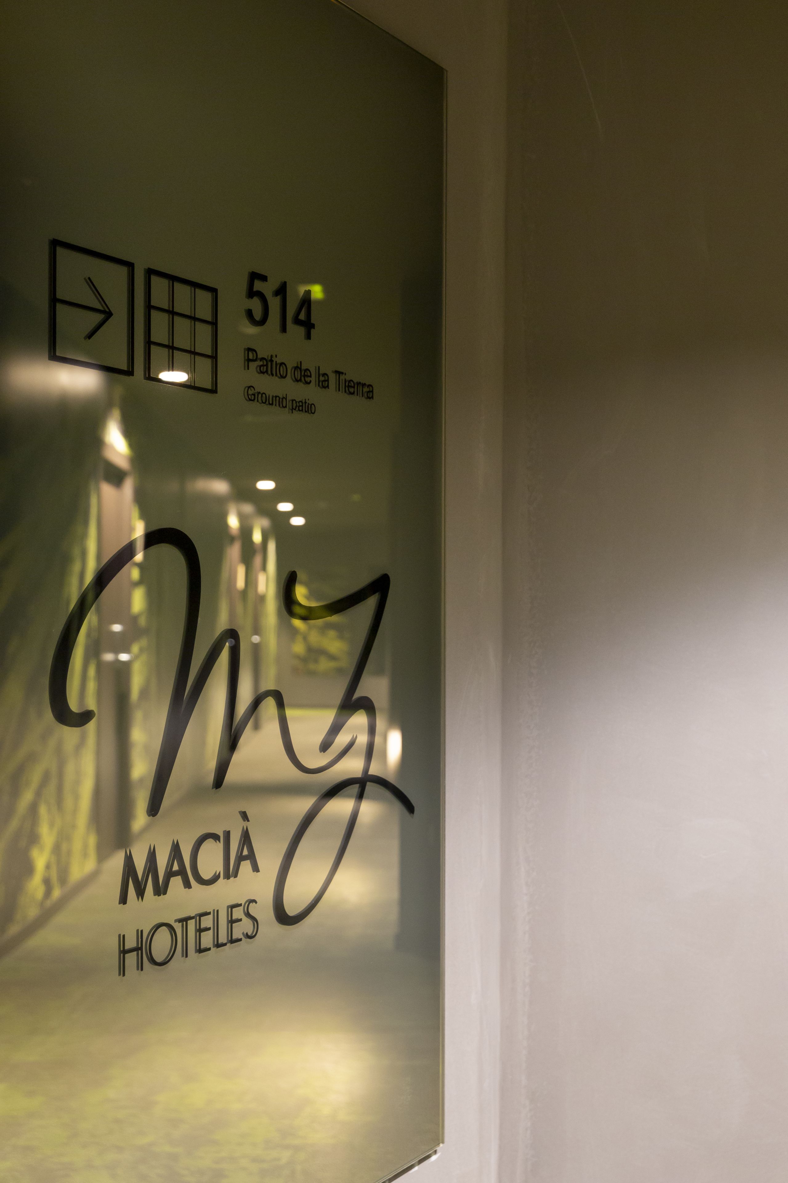 Un muro con una targa che indica la stanza numero 514, con l'etichetta 'Patio de la Tierra Ground Patio' e il logo 'MACHI HOTELES'.