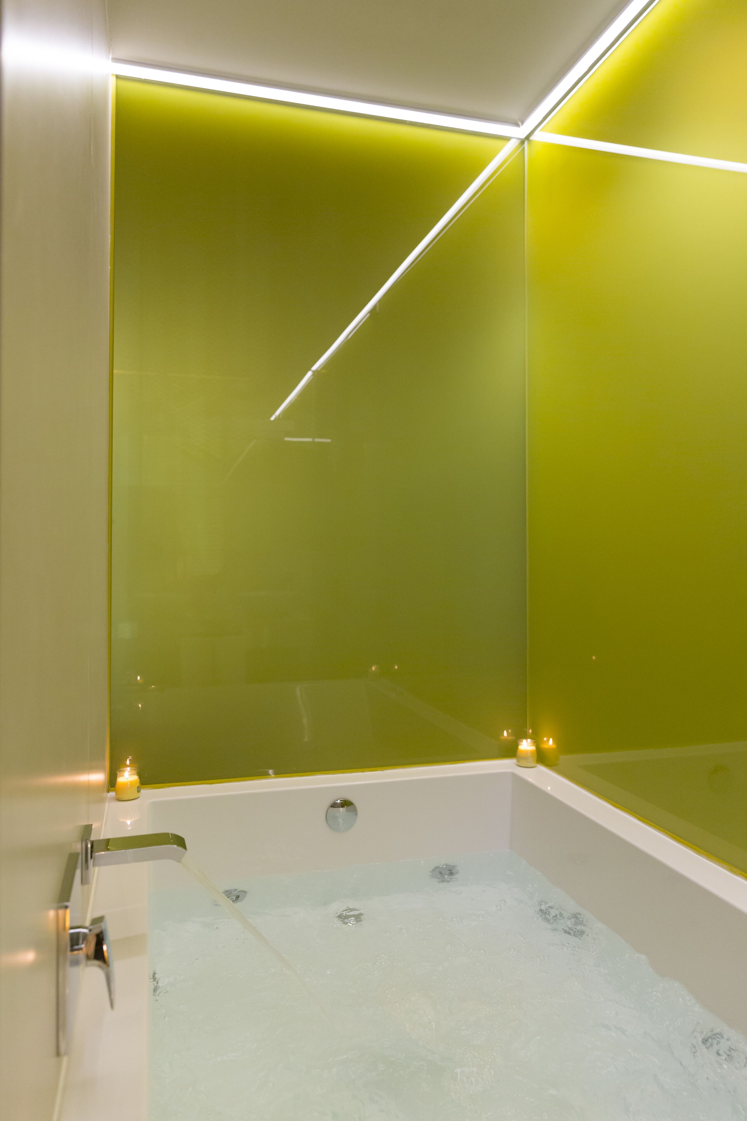 Un baño moderno con separador de vidrio, una bañera y un espejo.