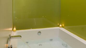 Un baño moderno con separador de vidrio, una bañera y un espejo.