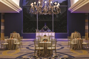 A banquet hall with round tables, chairs, and a chandelier. - Signia by Hilton San Jose (San Jose)