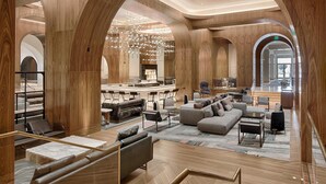 A spacious lobby with high wooden arches, a central seating area with sofas and chairs, and a bar with stools. - Signia by Hilton San Jose (San Jose)