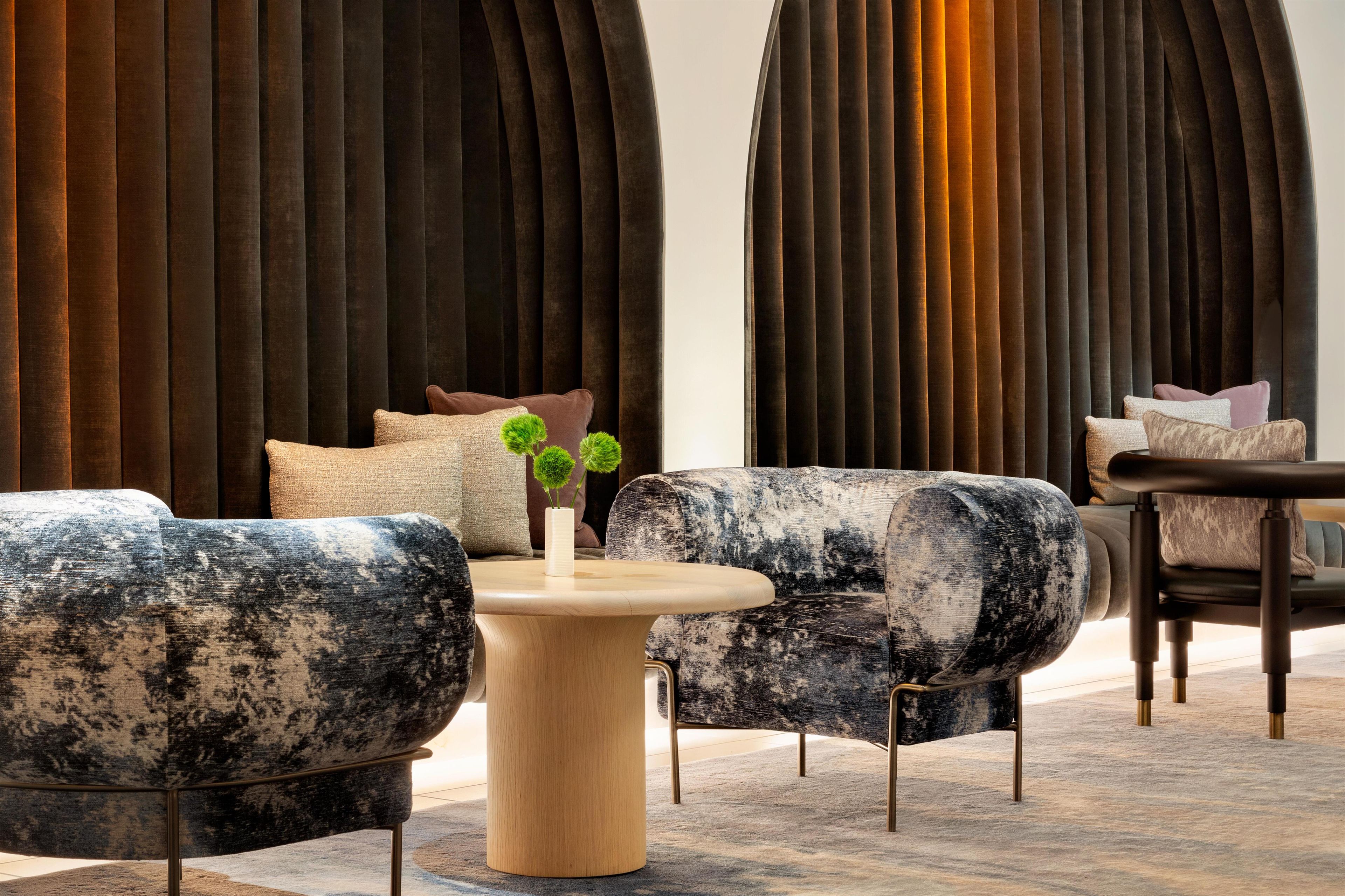 A modern lounge area with plush seating, a wooden coffee table, and a decorative plant.
