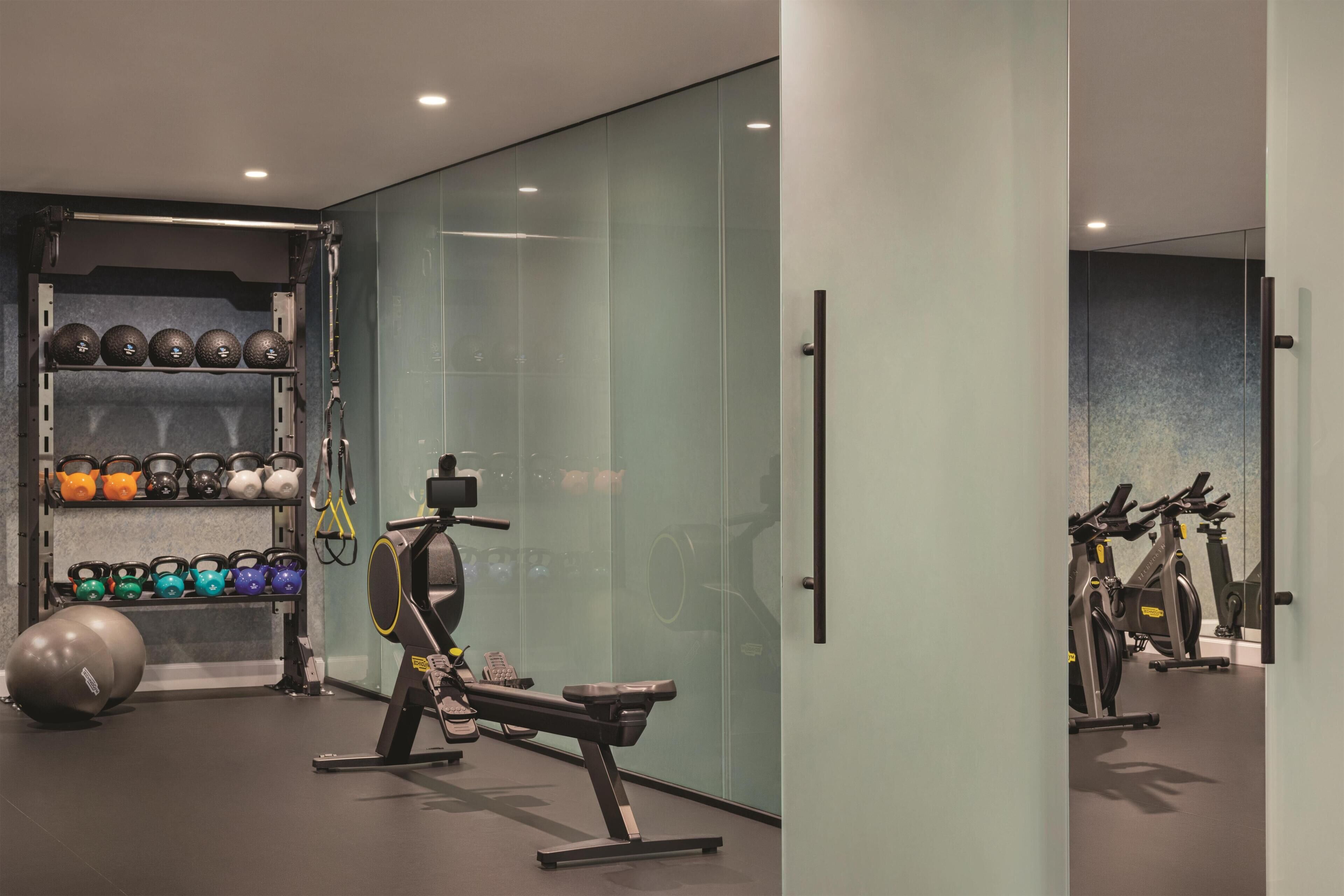 Et moderne fitnesscenter med træningsudstyr, vægtstativ og spejl.