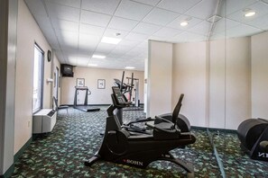 A hotel gym with exercise equipment, a treadmill, and a patterned carpet. - Econo Lodge (Greeneville)