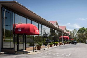 A hotel with a modern glass facade and red awnings labeled 'Econo Lodge.' - Econo Lodge (Greeneville)
