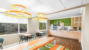 Un espace cuisine moderne avec des meubles en bois, un plan de travail équipé d’appareils électroménagers et une vue sur la verdure à l’extérieur.