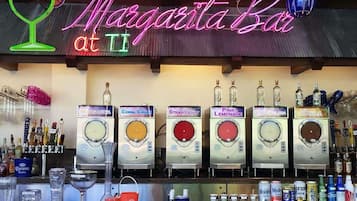 A bar named 'Margarita Bar at II' with multiple drink dispensers labeled with different beverages like Coral Crush, Strawberry, Pink Lemonade, and Cola.