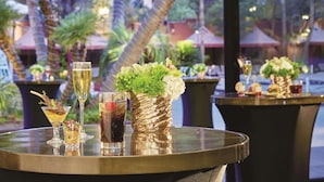 A bar area with a round table, various drinks, and decorative vases. - Treasure Island TI Las Vegas - Handwritten Collection (Las Vegas)