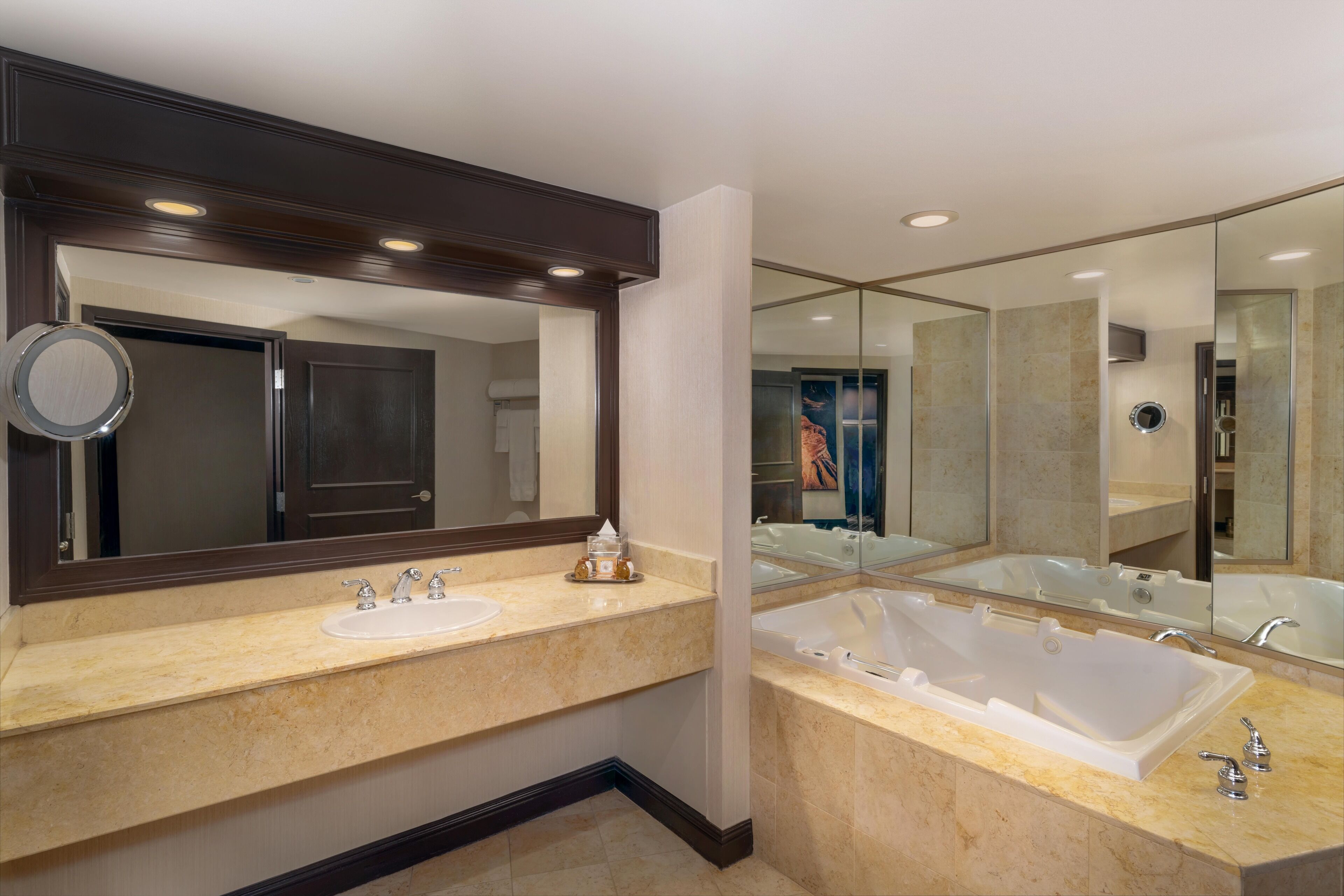 A modern bathroom with two sinks, a large bathtub, and a mirror.