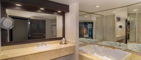 A modern bathroom with two sinks, a large bathtub, and a mirror.