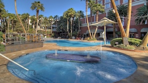 A hotel pool area with a hot tub, palm trees, and a building in the background. - Treasure Island TI Las Vegas - Handwritten Collection (Las Vegas)