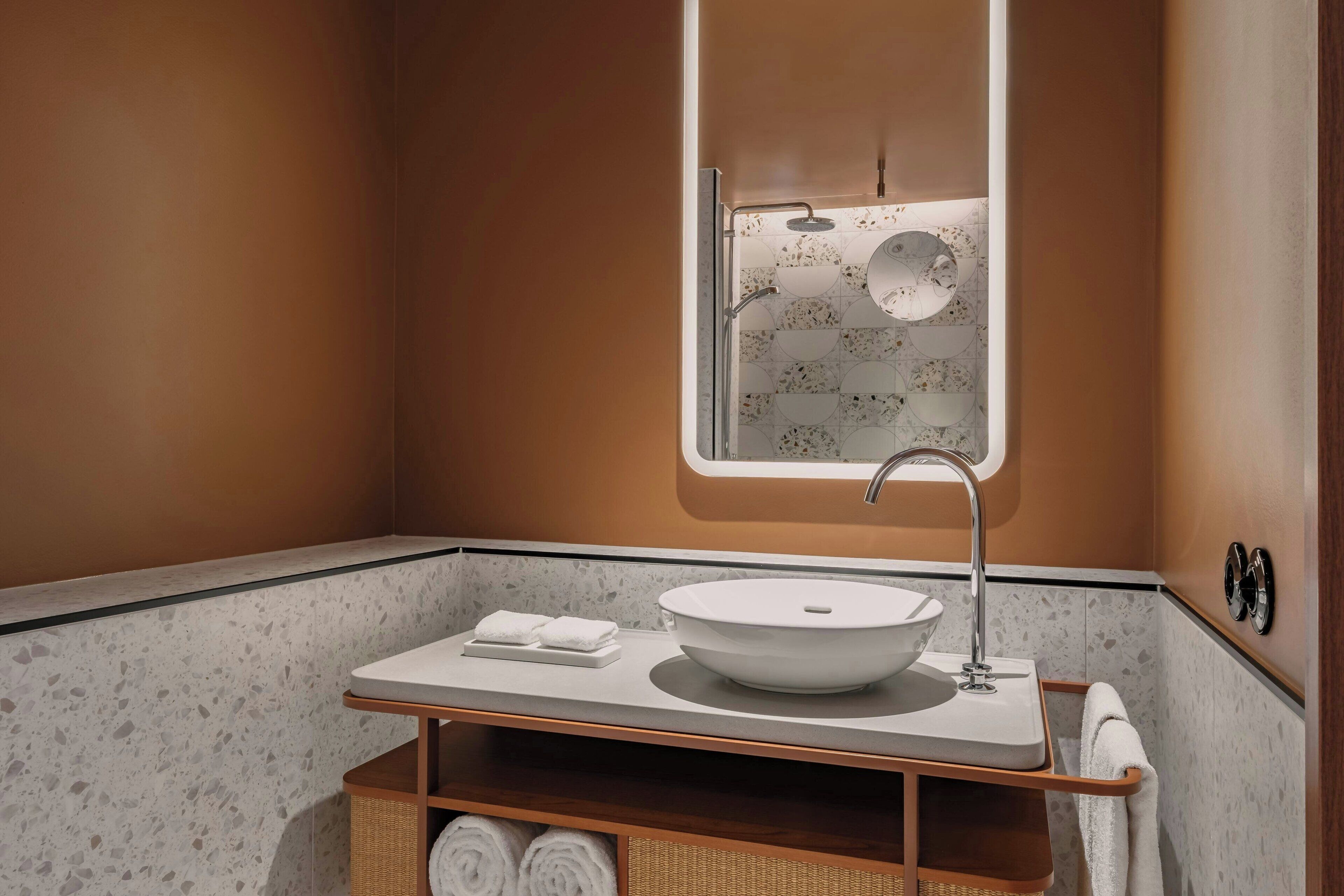 A bathroom with a white sink, a mirror, and a towel rack.