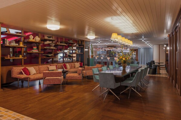 A modern interior with a wooden ceiling, a bar area, and a seating arrangement with a table and chairs.