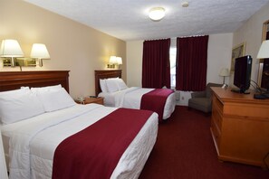 A hotel room with two beds, a desk, a chair, a dresser, and a television. - Knights Inn Oswego (Oswego)