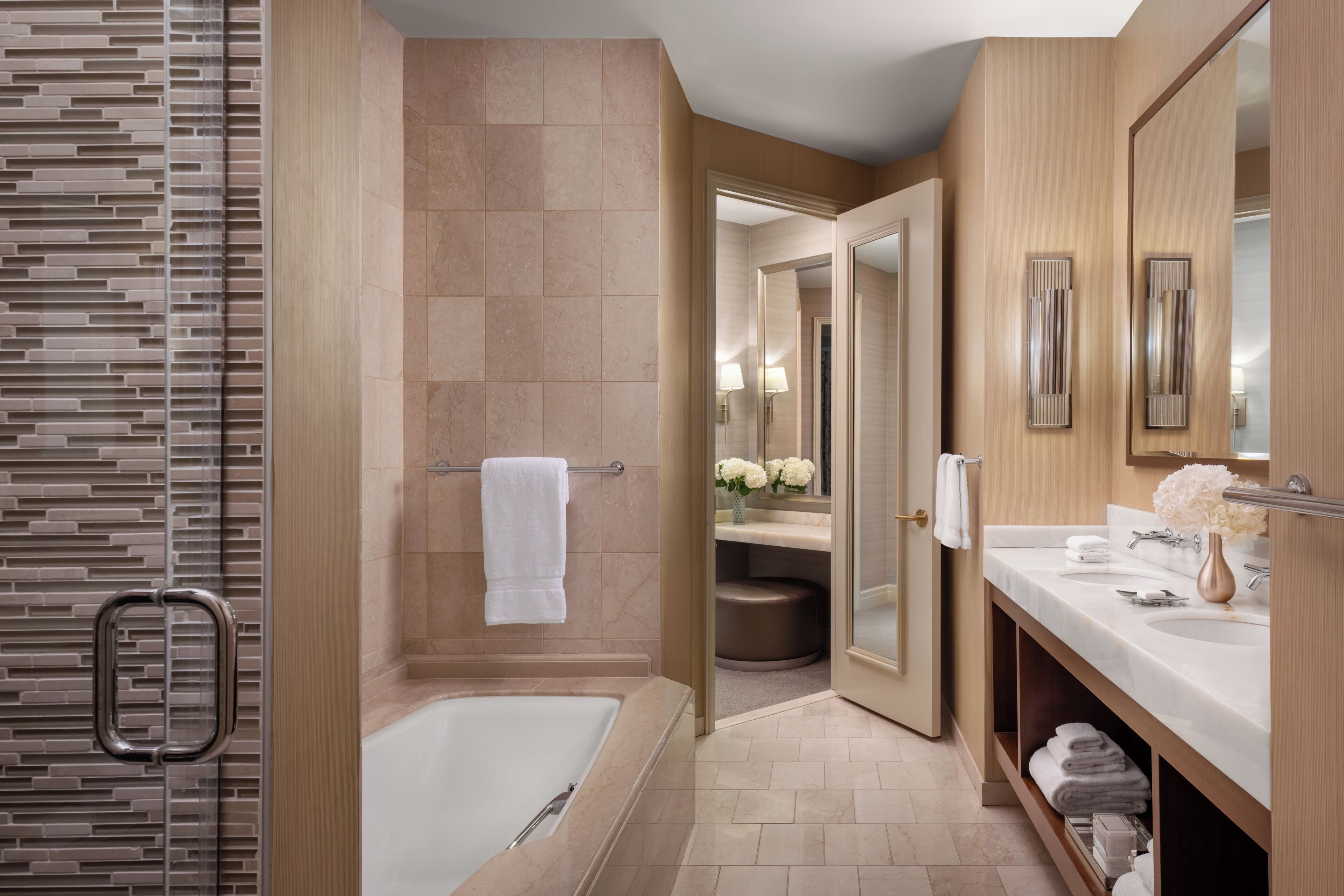 A modern bathroom with a bathtub, a shower, and a vanity with a mirror.