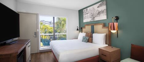 A hotel room with a bed, a television, a desk, and a chair.