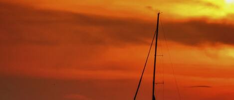 Un velero en aguas tranquilas durante el atardecer.