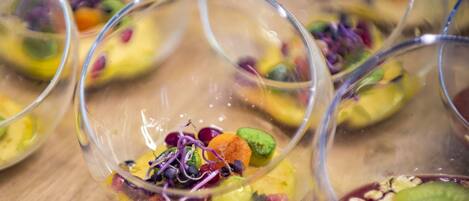 A dessert presentation with various fruits and nuts in clear glass bowls.