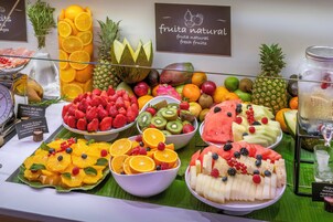 A fruit display with various fresh fruits and a sign indicating 'fruta natural'.