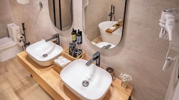 A modern bathroom with two sinks, a mirror, and a towel rack.