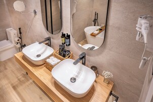 Un baño moderno con dos lavamanos, un espejo y un perchero para toallas.