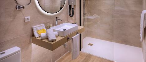 A modern bathroom with a sink, mirror, and shower.