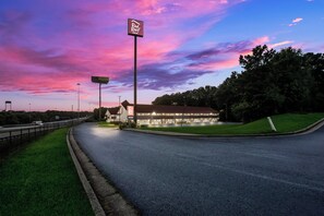A Red Roof Inn with a large sign, located beside a highway with a grassy area and trees. - Red Roof Inn Atlanta South - Morrow (Morrow)