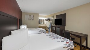 A hotel room with two beds, a desk, a television, and a mirror. - Red Roof Inn Atlanta South - Morrow (Morrow)