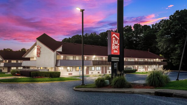 Un Red Roof Inn con diseño moderno, que cuenta con estacionamiento y jardines bien cuidados.