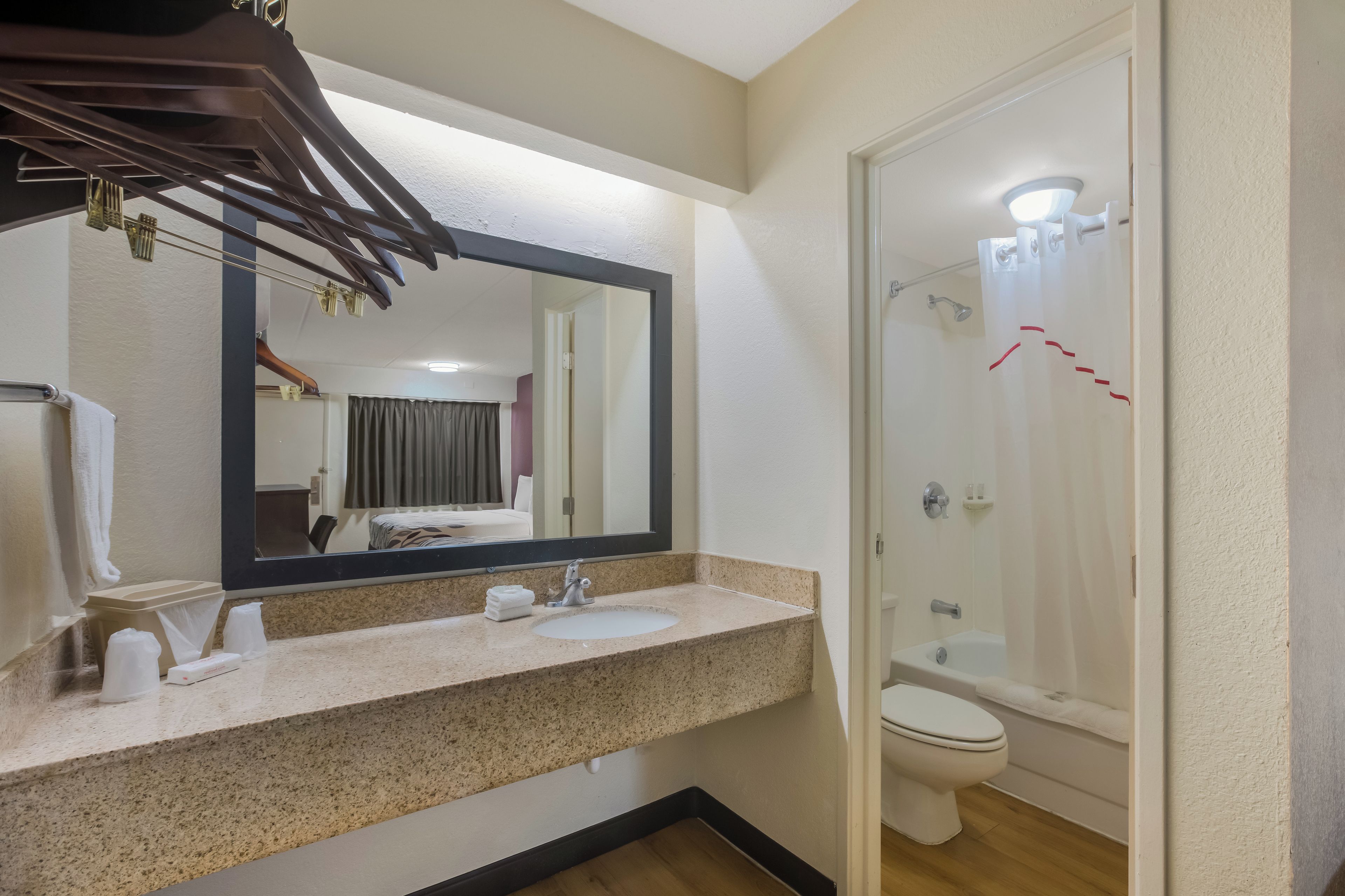 Ein Badezimmer mit Waschbecken, Spiegel, Toilette und Dusche.