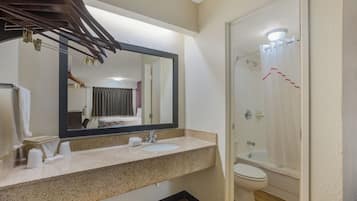 Ein Badezimmer mit Waschbecken, Spiegel, Toilette und Dusche.