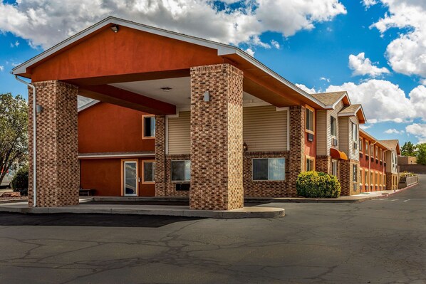 Stylish motel with a distinctive architectural style, featuring a flat roof and brick pillars.
