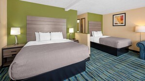 A hotel room with two beds, a mirror, a lamp, and a framed picture on the wall. - Quality Inn Los Lunas - Albuquerque South (Los Lunas)