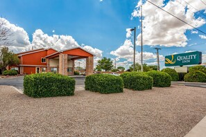 Welcome to Quality Inn, featuring a red brick facade and a covered entrance area.