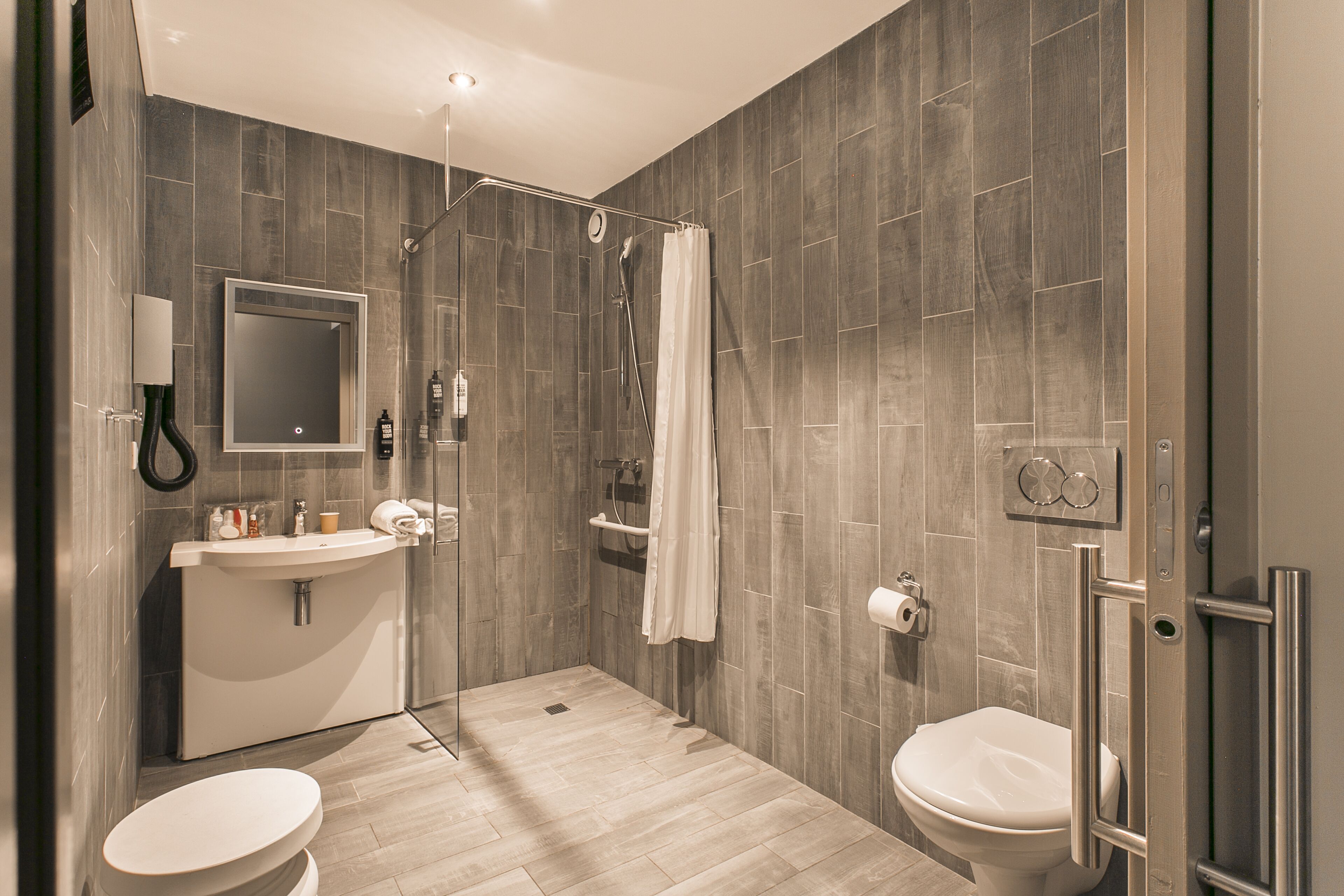 Un baño moderno con ducha, inodoro y lavamanos.