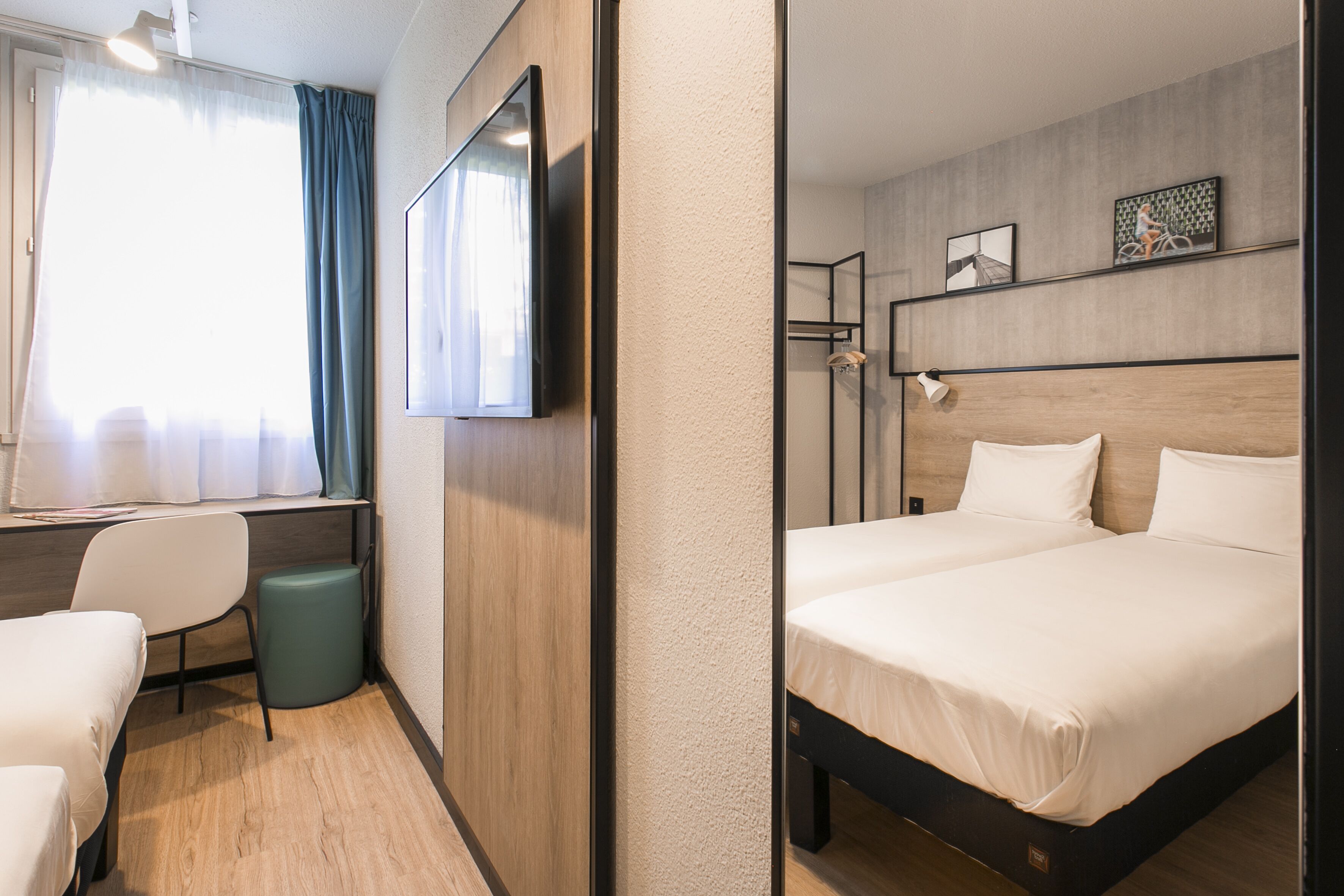 Een hotelkamer met een bed, een bureau, een stoel en een televisie.