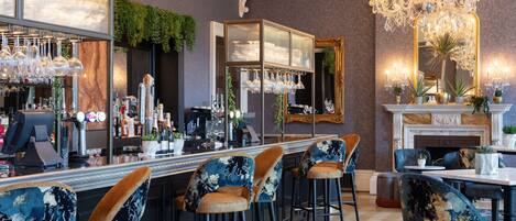 A bar area with high stools, a bar counter, and a large mirror.